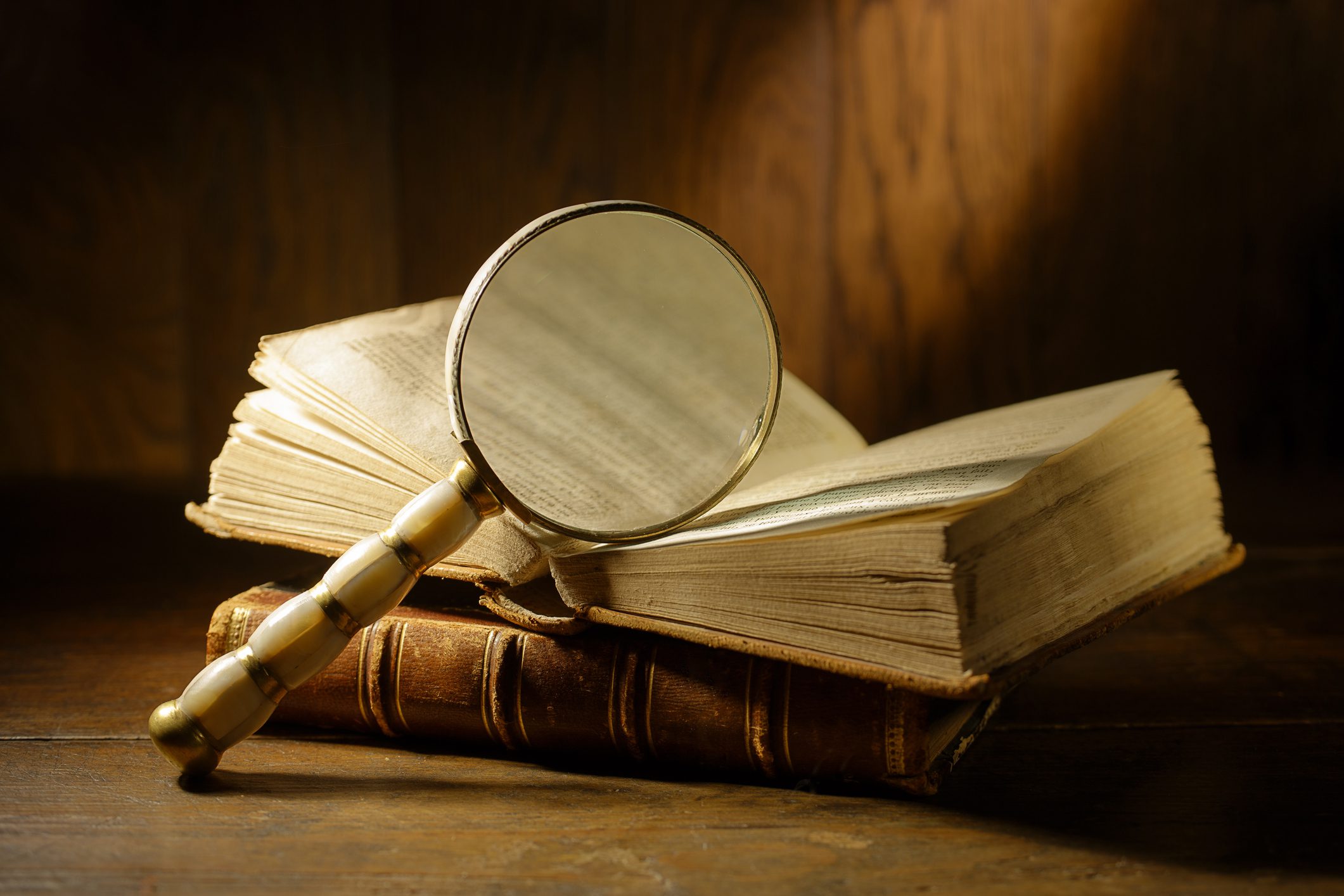 Magnifying glass over open book on table.