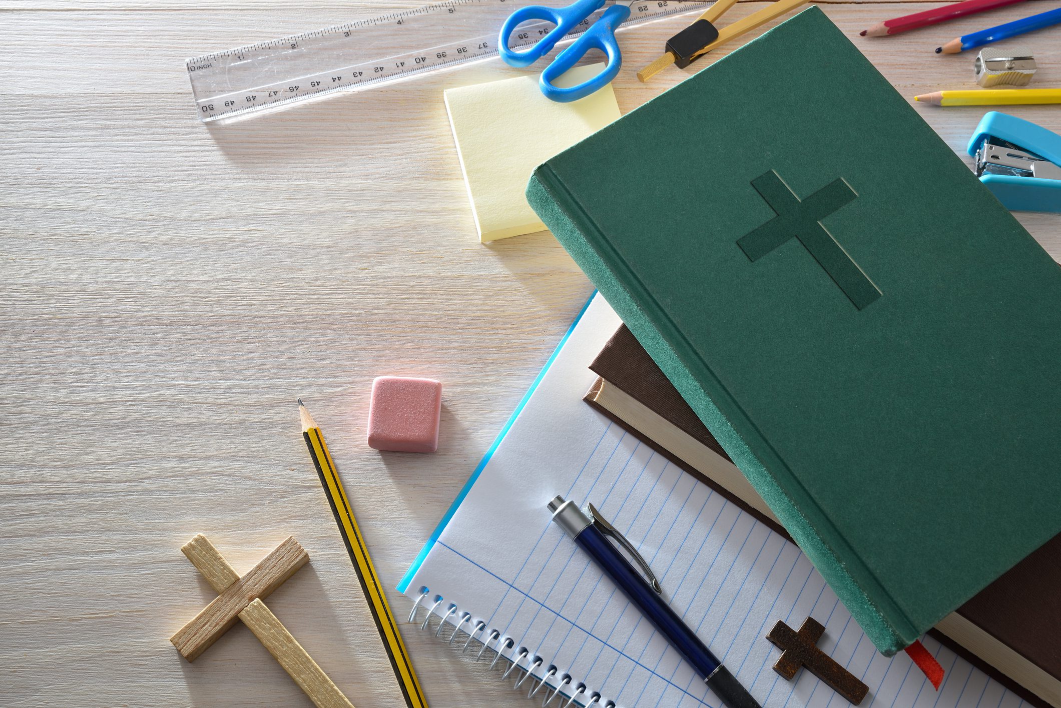 Christian book and stationery on wooden table.