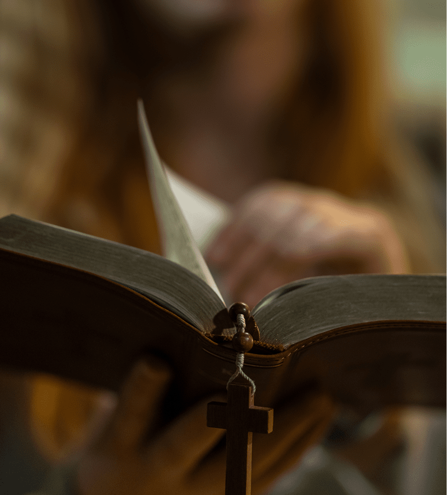 Open Bible with a wooden cross bookmark.
