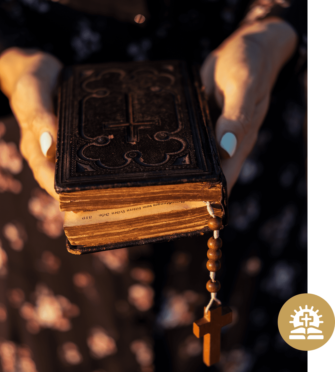Hands holding an old book with rosary.