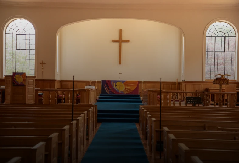 Church interior with pews and cross.